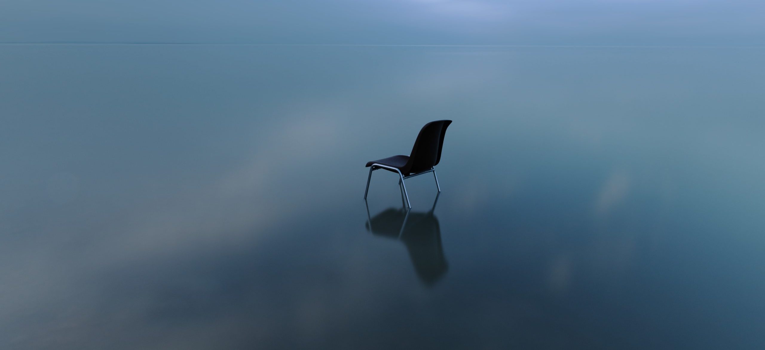 Una silla reflexionando sobre la superficie del agua en un día tormentoso