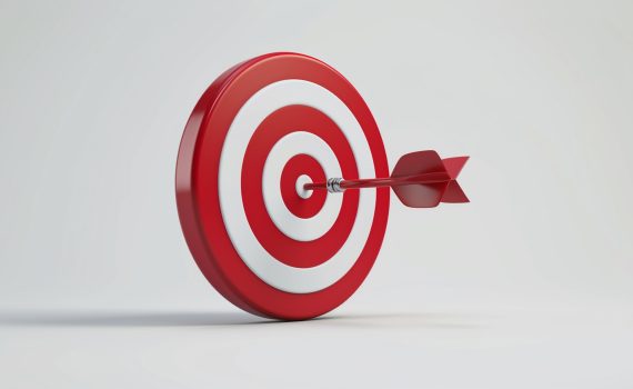 Fondo blanco y sobre él una diana con franjas naranjas y blancas que tiene un dardo clavado en el centro.