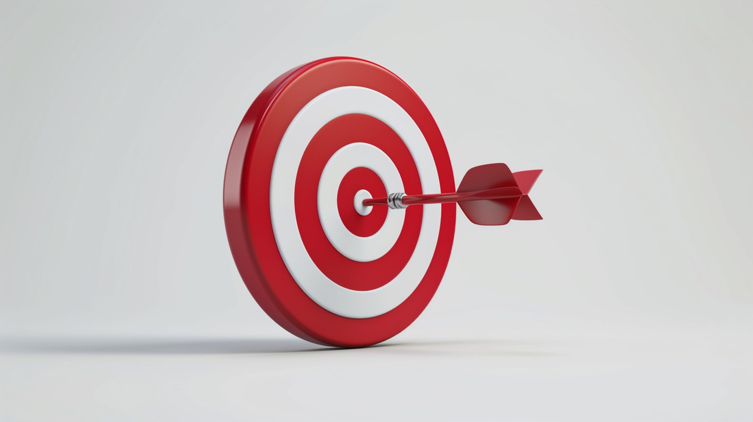 Fondo blanco y sobre él una diana con franjas naranjas y blancas que tiene un dardo clavado en el centro.